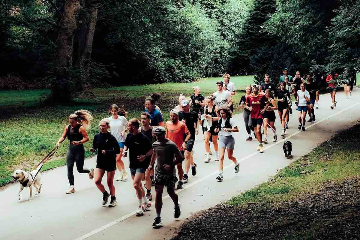 Group of runners and a dog through a park for Run Happy Run Club, Sheffield