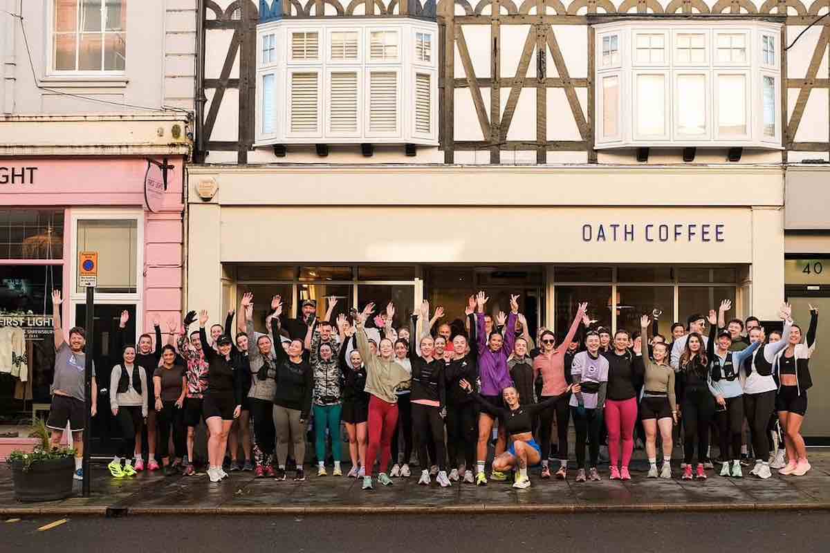 Runners line up outside Oath Coffee Run Social waving at the camera