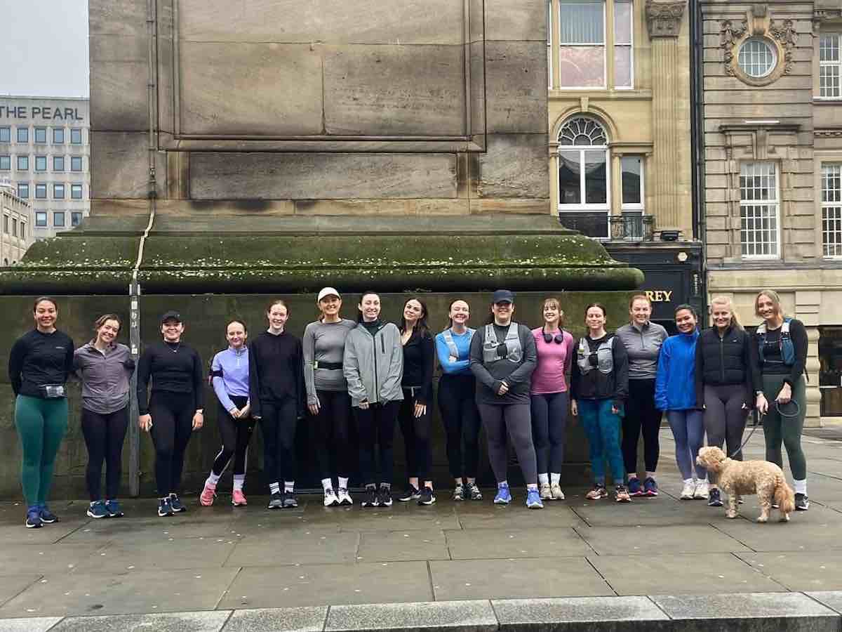 Group photo of Croissant Run Club, standing in front of a monument in Newcastle