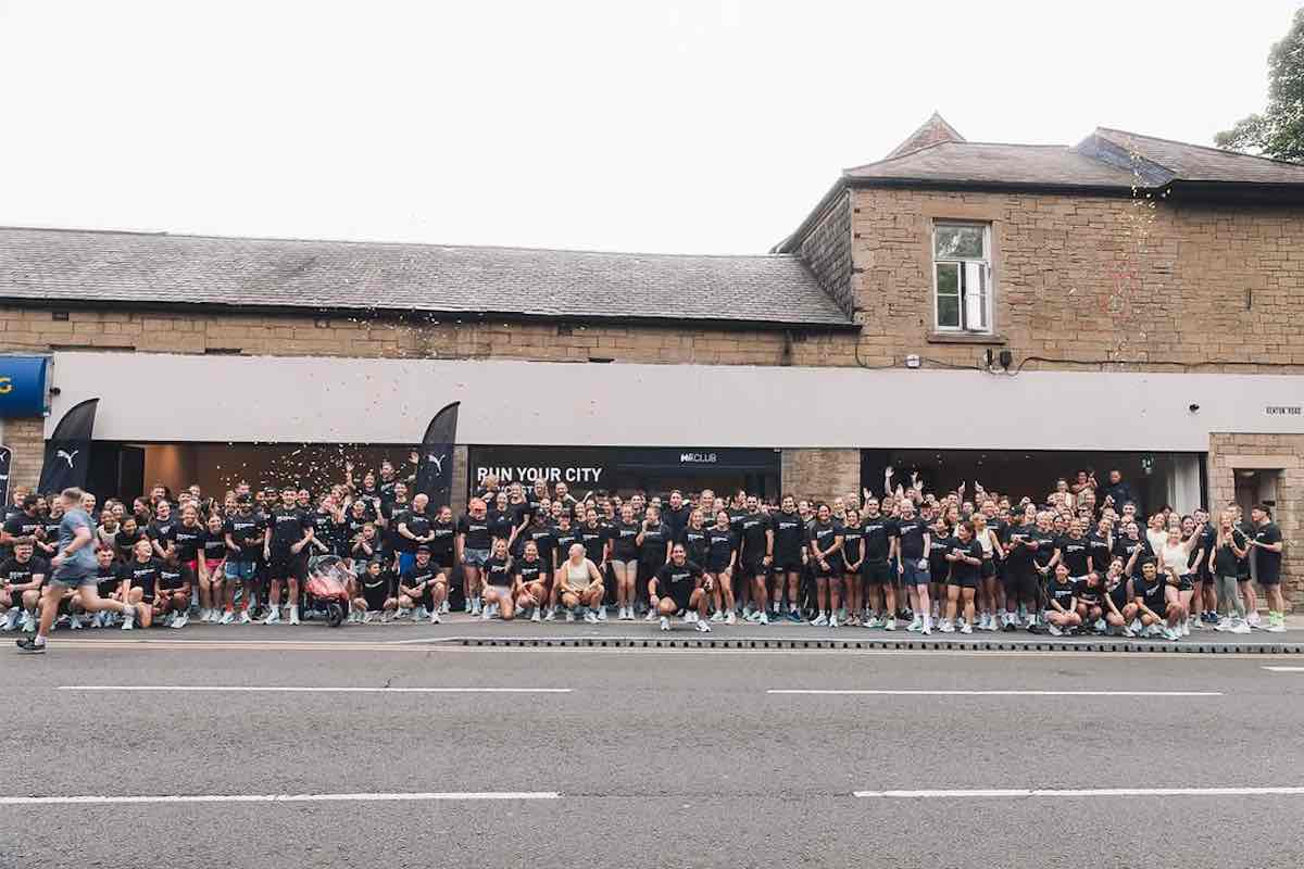 Hundreds of runners from Hii Run Club Newcastle line up in black and white matching merch