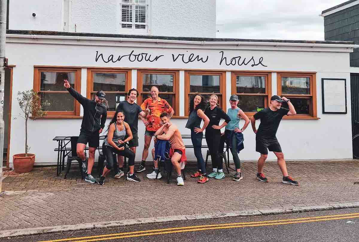 The Stride Run Club St Ives, posing for a group photo outside Harbour View House Café