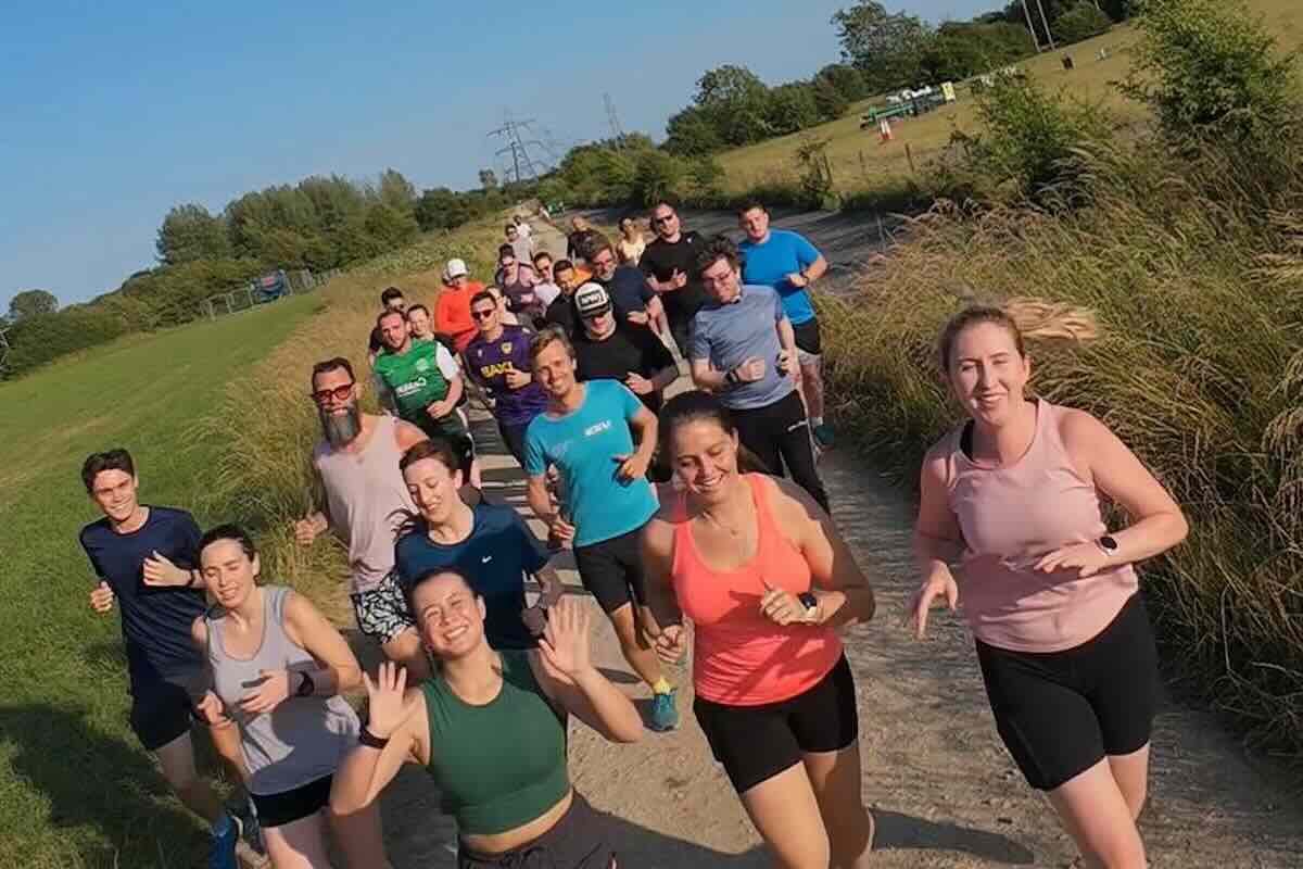 Group of Run Tribe run club runners on a trail path on a sunny day